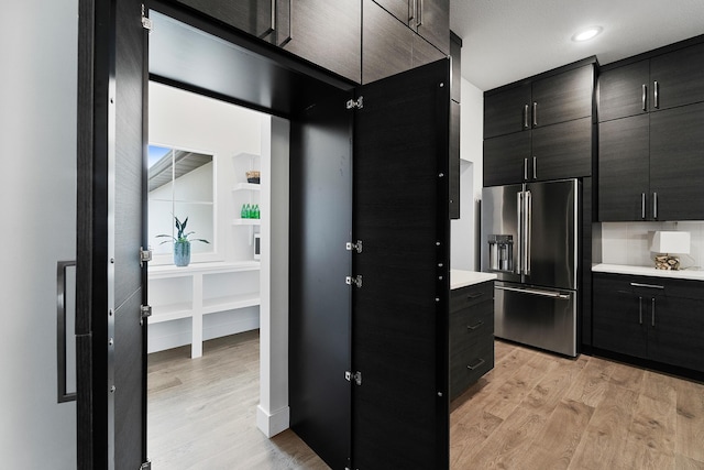 kitchen featuring light wood-style floors, high end fridge, light countertops, and modern cabinets