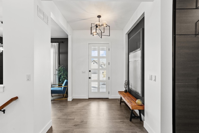 foyer with dark wood-style floors, a chandelier, visible vents, and baseboards