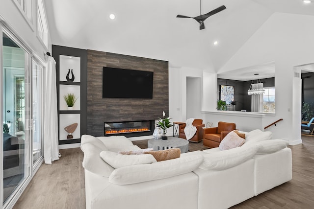 living room featuring light wood-style floors, a fireplace, and high vaulted ceiling