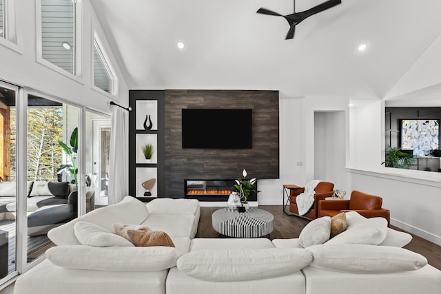 living area with a ceiling fan, a fireplace, baseboards, and wood finished floors