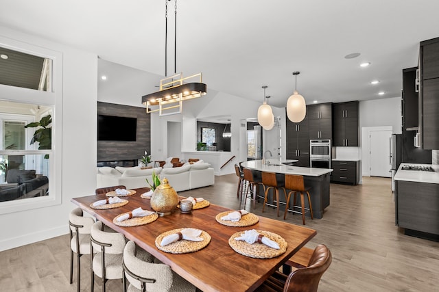 dining area with light wood finished floors and recessed lighting