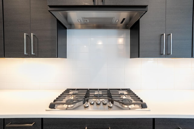 kitchen featuring light countertops, ventilation hood, decorative backsplash, modern cabinets, and stainless steel gas stovetop