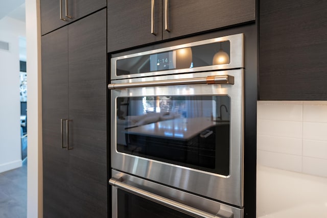 interior details with stainless steel double oven, visible vents, and modern cabinets