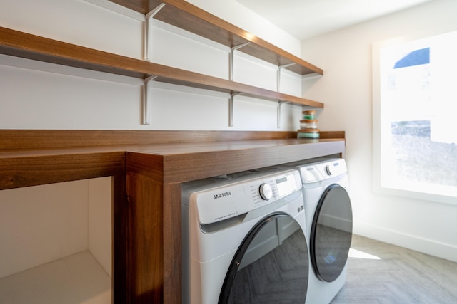 washroom featuring laundry area, baseboards, and washing machine and clothes dryer