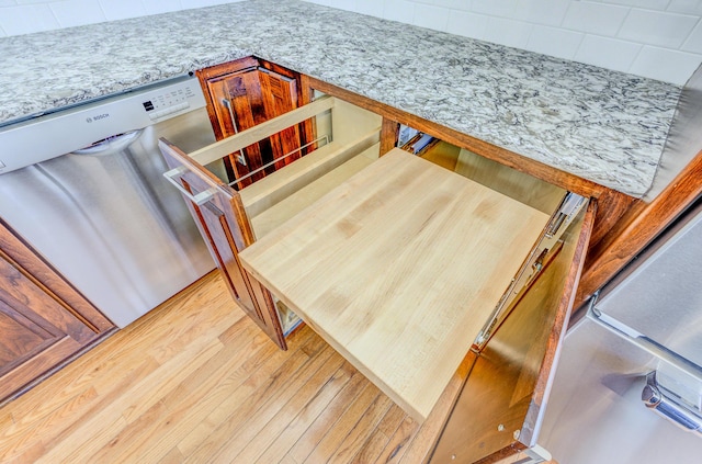 interior details featuring stainless steel dishwasher and wood finished floors