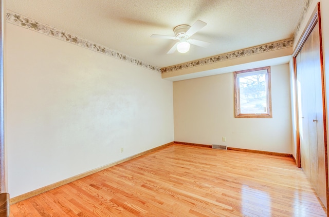 unfurnished bedroom featuring visible vents, light wood-style floors, and a closet