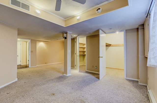 finished basement with baseboards, visible vents, carpet floors, and a baseboard radiator