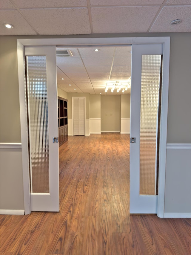 spare room featuring recessed lighting, wood finished floors, baseboards, and a drop ceiling