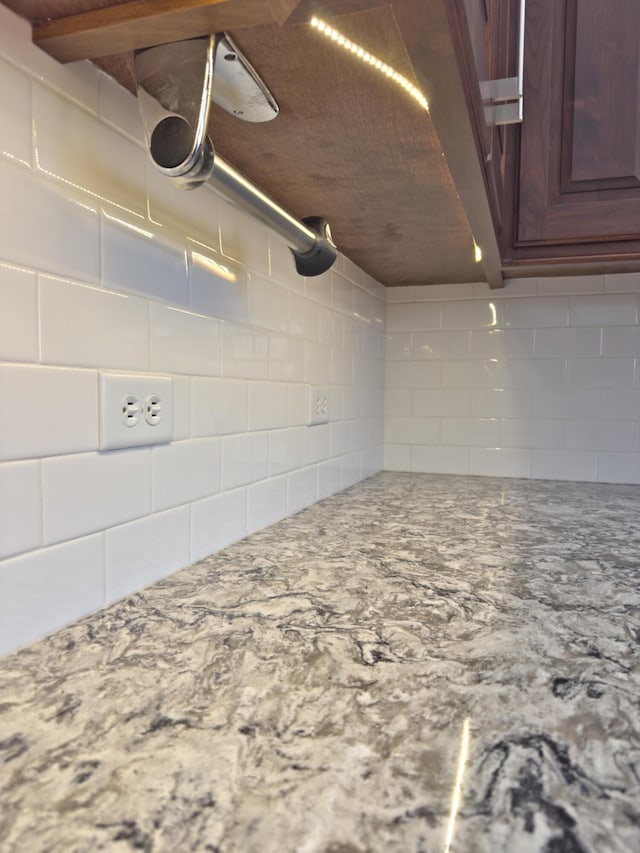 interior details featuring light stone countertops and tasteful backsplash