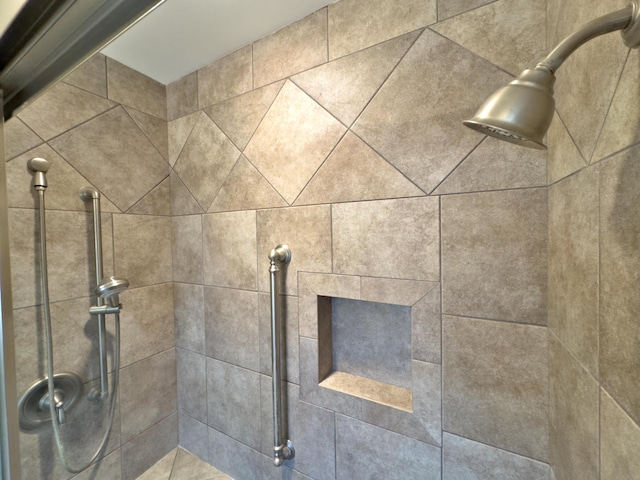 interior details featuring a tile shower