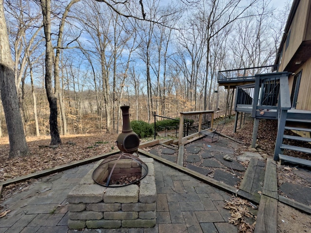 view of patio featuring a deck, stairs, and a fire pit