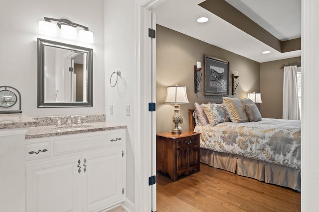 bedroom with light wood finished floors, a sink, and recessed lighting