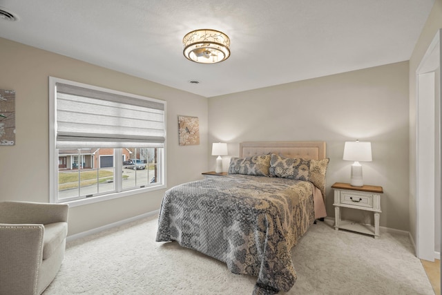 bedroom with visible vents, baseboards, and light colored carpet