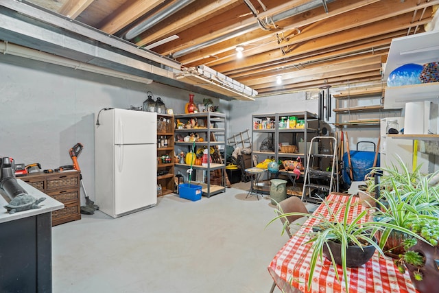 unfinished basement featuring freestanding refrigerator