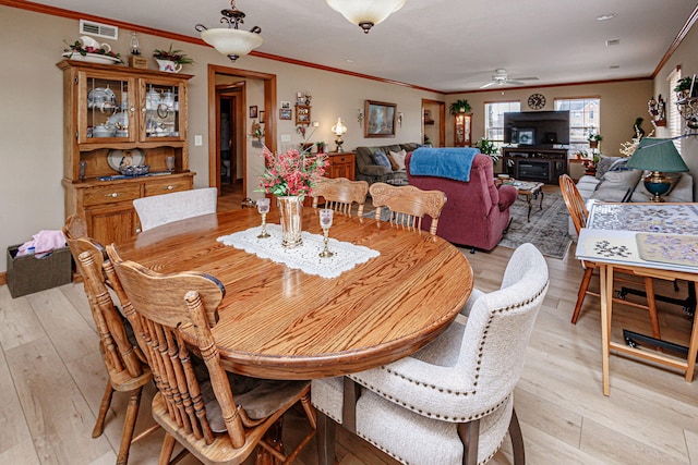 dining area featuring ornamental molding, light hardwood / wood-style floors, and ceiling fan