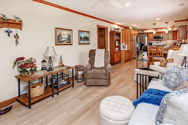 living room with crown molding, ceiling fan, and light wood-type flooring