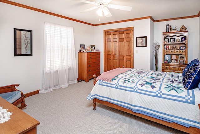 bedroom with ceiling fan, ornamental molding, carpet flooring, and a closet