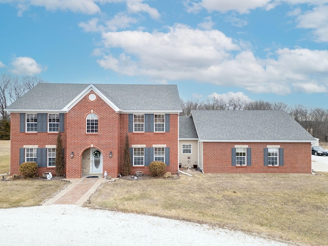 colonial house featuring a front lawn