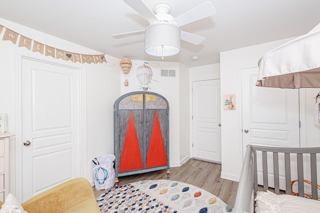 bedroom with light wood-style floors, ceiling fan, and baseboards