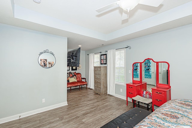 bedroom featuring baseboards, wood finished floors, and a ceiling fan