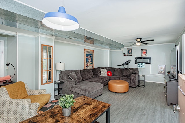 living room with wood finished floors, a ceiling fan, and baseboards