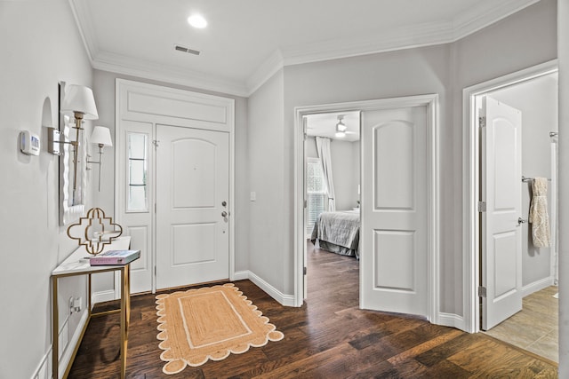 entrance foyer featuring ornamental molding, visible vents, baseboards, and wood finished floors