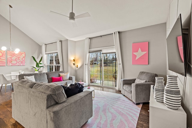 living room with lofted ceiling, dark wood-style floors, and ceiling fan with notable chandelier