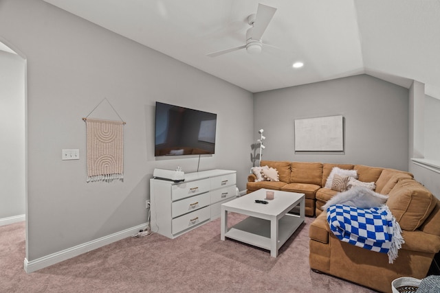 living area with light carpet, ceiling fan, baseboards, and vaulted ceiling