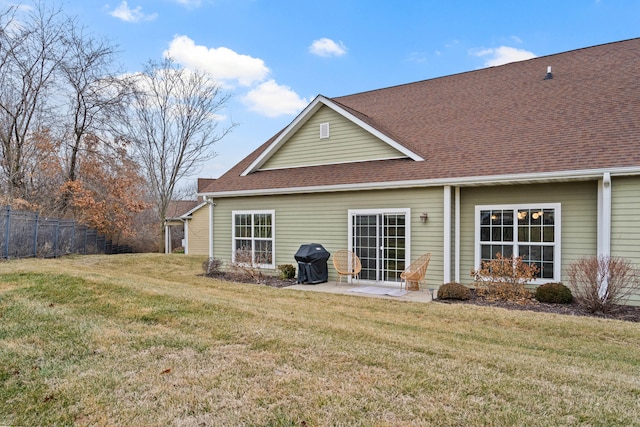 rear view of house featuring a yard, a shingled roof, a patio area, and fence