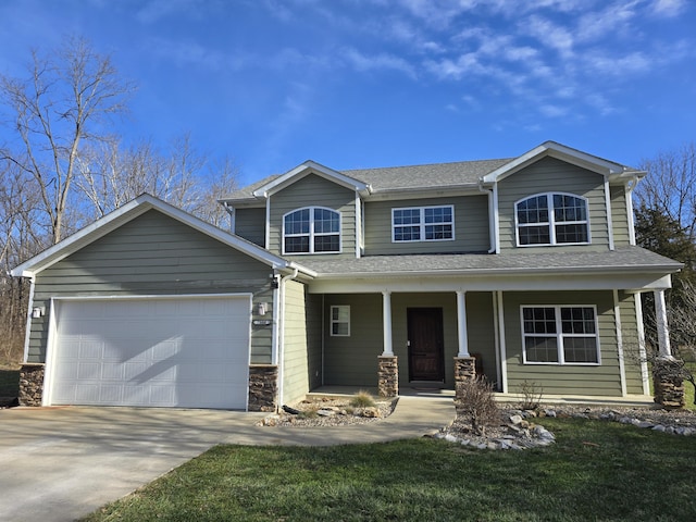 view of front of house featuring a garage, a porch, and a front yard