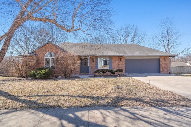 ranch-style house with brick siding, driveway, an attached garage, and fence