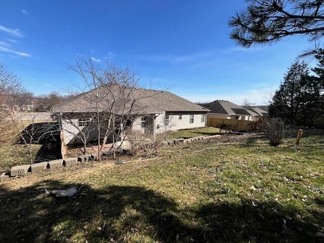 rear view of property featuring fence