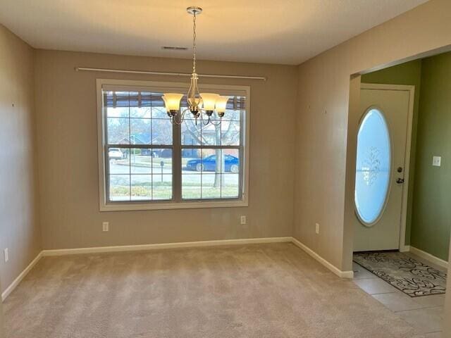 foyer entrance featuring baseboards, carpet, visible vents, and an inviting chandelier