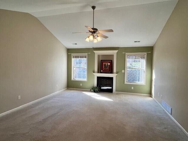 unfurnished living room featuring plenty of natural light, vaulted ceiling, visible vents, and a fireplace