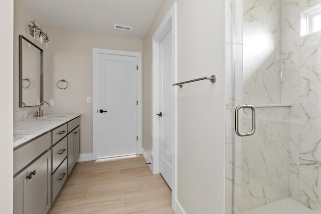 4509 Royal County Rd, Columbia, MO 65201 - full bathroom with visible vents, baseboards, double vanity, a marble finish shower, and a sink