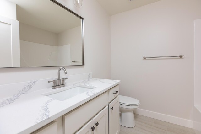 4509 Royal County Rd, Columbia, MO 65201 - bathroom with baseboards, toilet, vanity, and wood finished floors