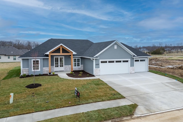 4509 Royal County Rd, Columbia, MO 65201 - craftsman-style house featuring a front yard, stone siding, french doors, concrete driveway, and a garage