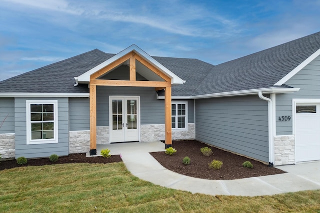 4509 Royal County Rd, Columbia, MO 65201 - exterior space with stone siding, french doors, roof with shingles, a front lawn, and a garage