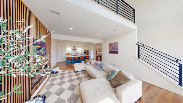 living room featuring stairway, recessed lighting, visible vents, and light wood-style floors