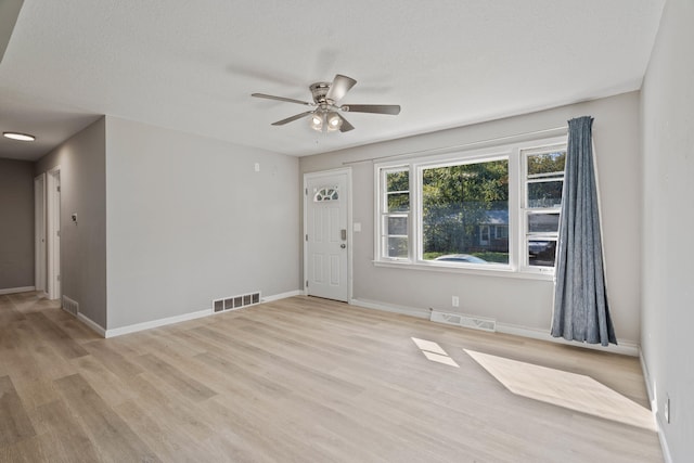 foyer entrance with a textured ceiling, light hardwood / wood-style floors, and ceiling fan