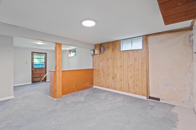 basement featuring wooden walls