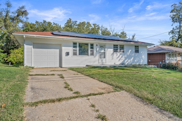 ranch-style home with a garage, a front lawn, and solar panels