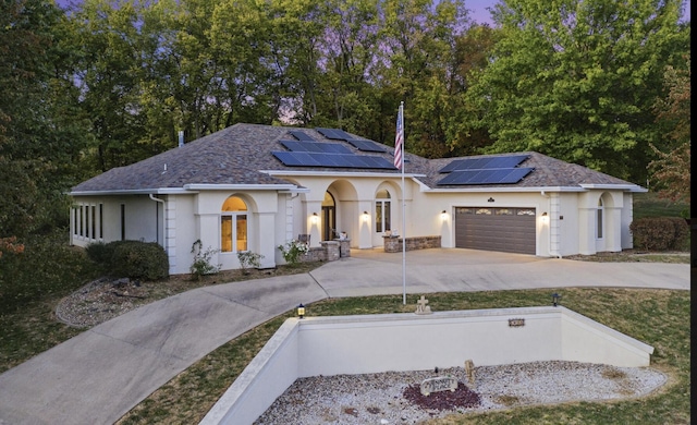 view of front facade with a garage and solar panels