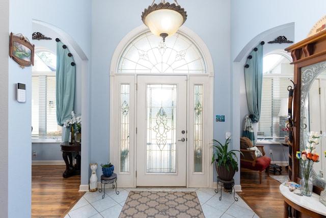 foyer entrance with light tile patterned flooring and a high ceiling