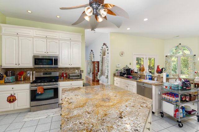 kitchen featuring tasteful backsplash, appliances with stainless steel finishes, and white cabinets