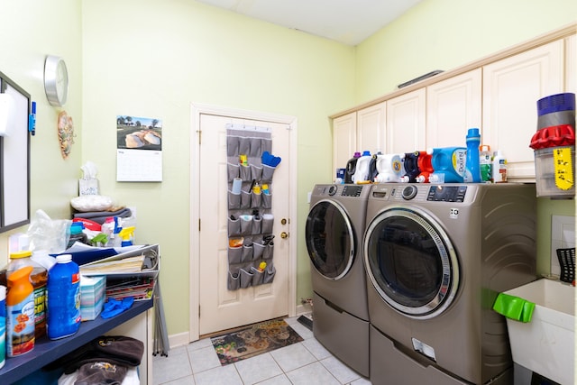 washroom with cabinets, sink, light tile patterned floors, and washing machine and clothes dryer