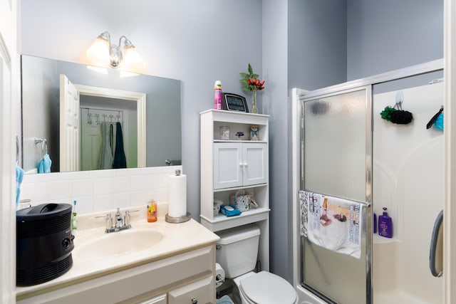 bathroom featuring walk in shower, vanity, toilet, and decorative backsplash