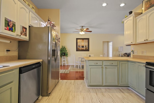 kitchen with stainless steel appliances, ceiling fan, light wood-type flooring, and kitchen peninsula