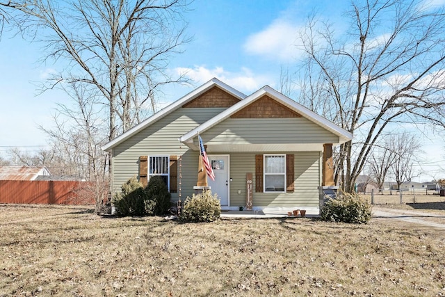 bungalow-style home featuring a porch and fence