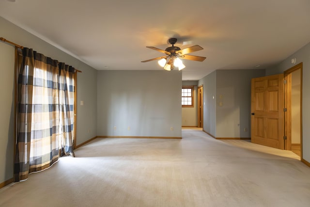 spare room featuring ceiling fan and light colored carpet